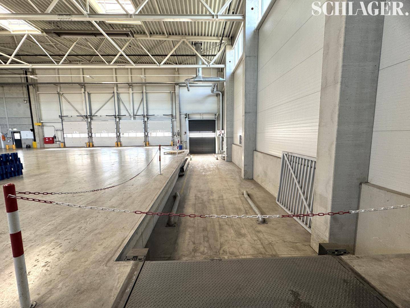 Ladebereich innerhalb der Halle mit erhöhter Rampe und Absperrketten für den Betrieb.