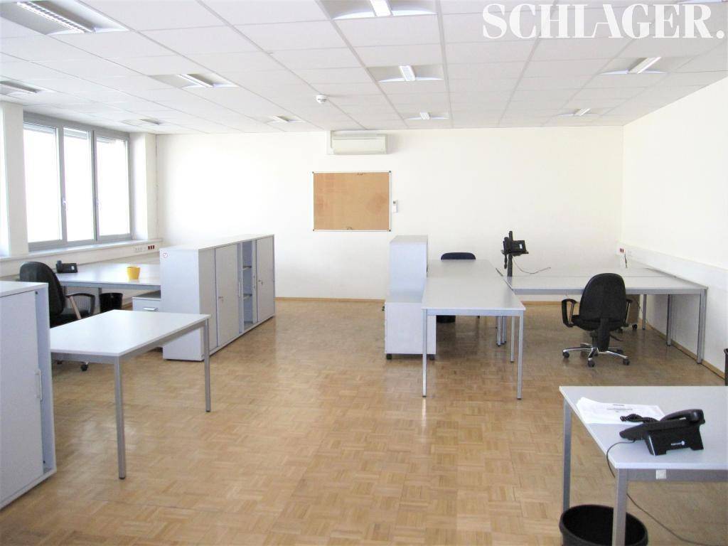 Helles Büro mit mehreren Arbeitsplätzen, Schränken und Klimaanlage, gut beleuchtet.