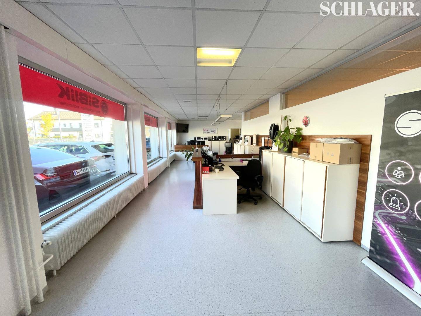 Geräumiger Bürobereich mit großen Schaufenstern, die den Blick nach draußen freigeben und viel Helligkeit bieten.