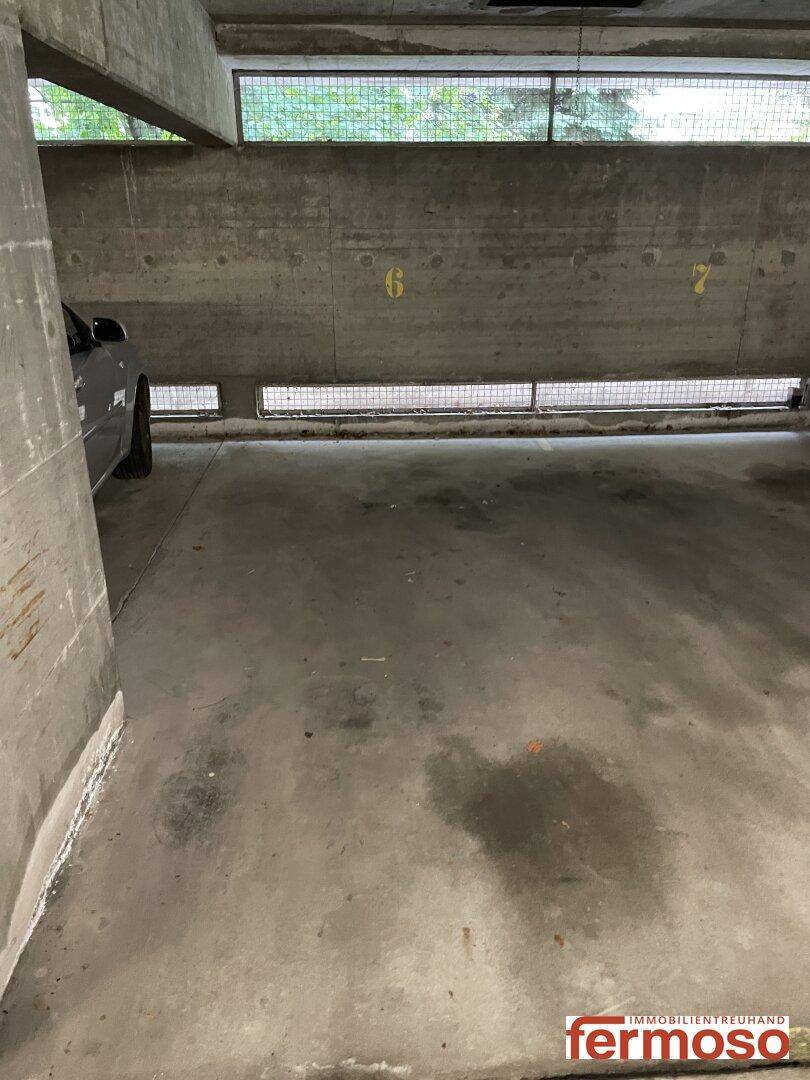 Betonierter Stellplatz in der Tiefgarage mit Lüftungsfenstern und natürlichem Lichteinfall.