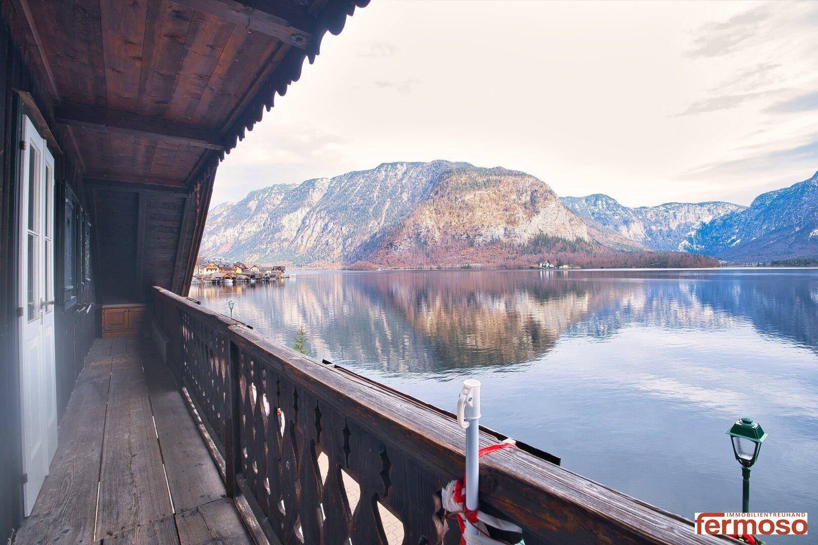 Geräumiger Holzbalkon mit atemberaubendem Blick auf den See und die Berge, ideal für Erholung.