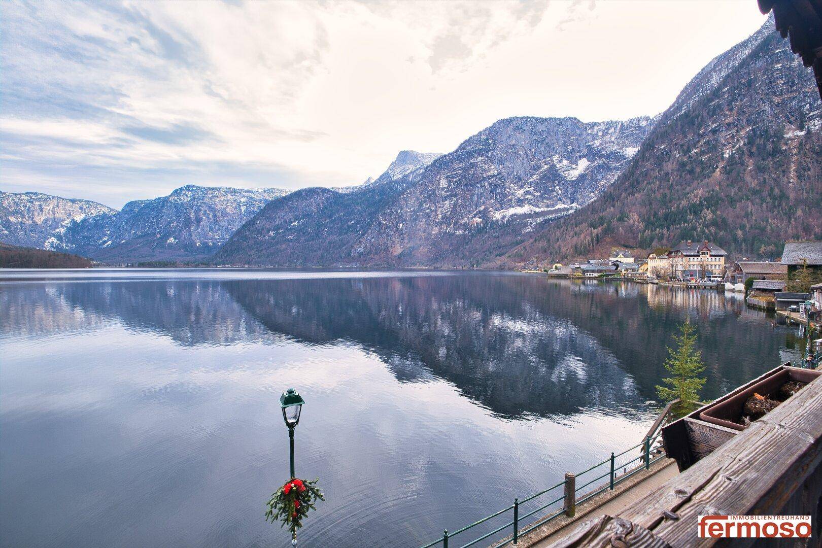 Panoramablick auf den ruhigen See und die majestätischen Berge unter bewölktem Himmel.