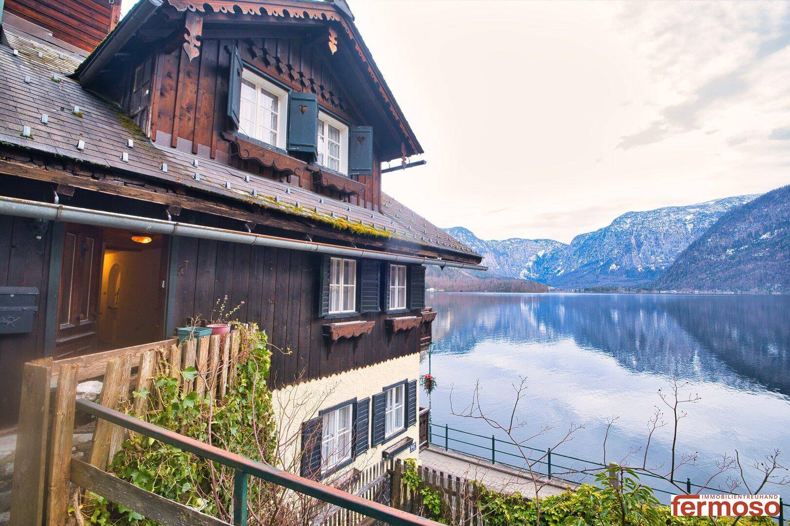 Detailansicht der traditionellen Holzfassade eines Hauses am See mit Blick auf die Berge.