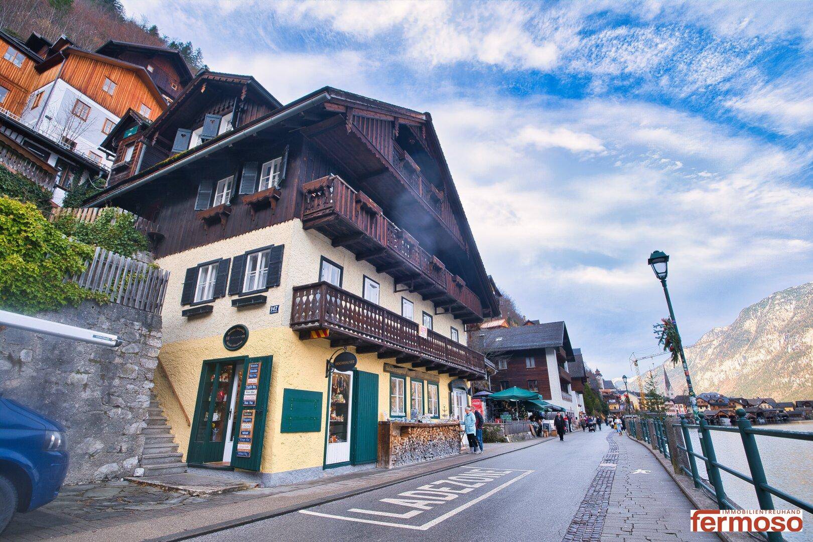 Straßenansicht eines traditionellen Gebäudes mit Geschäften im Erdgeschoss, direkt am Seeufer gelegen.