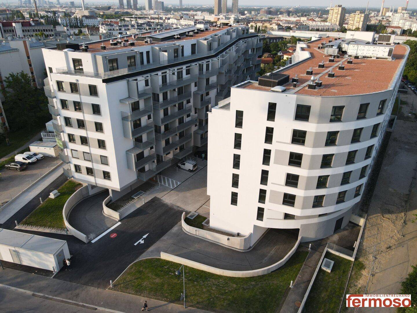 Moderne Wohnanlage mit geschwungenen Fassaden und begrünten Außenbereichen.
