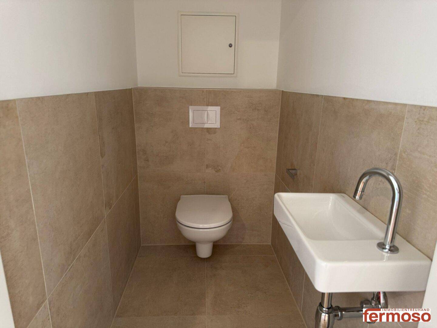 Kleines Gäste-WC mit Wand-WC und modernem Waschbecken.