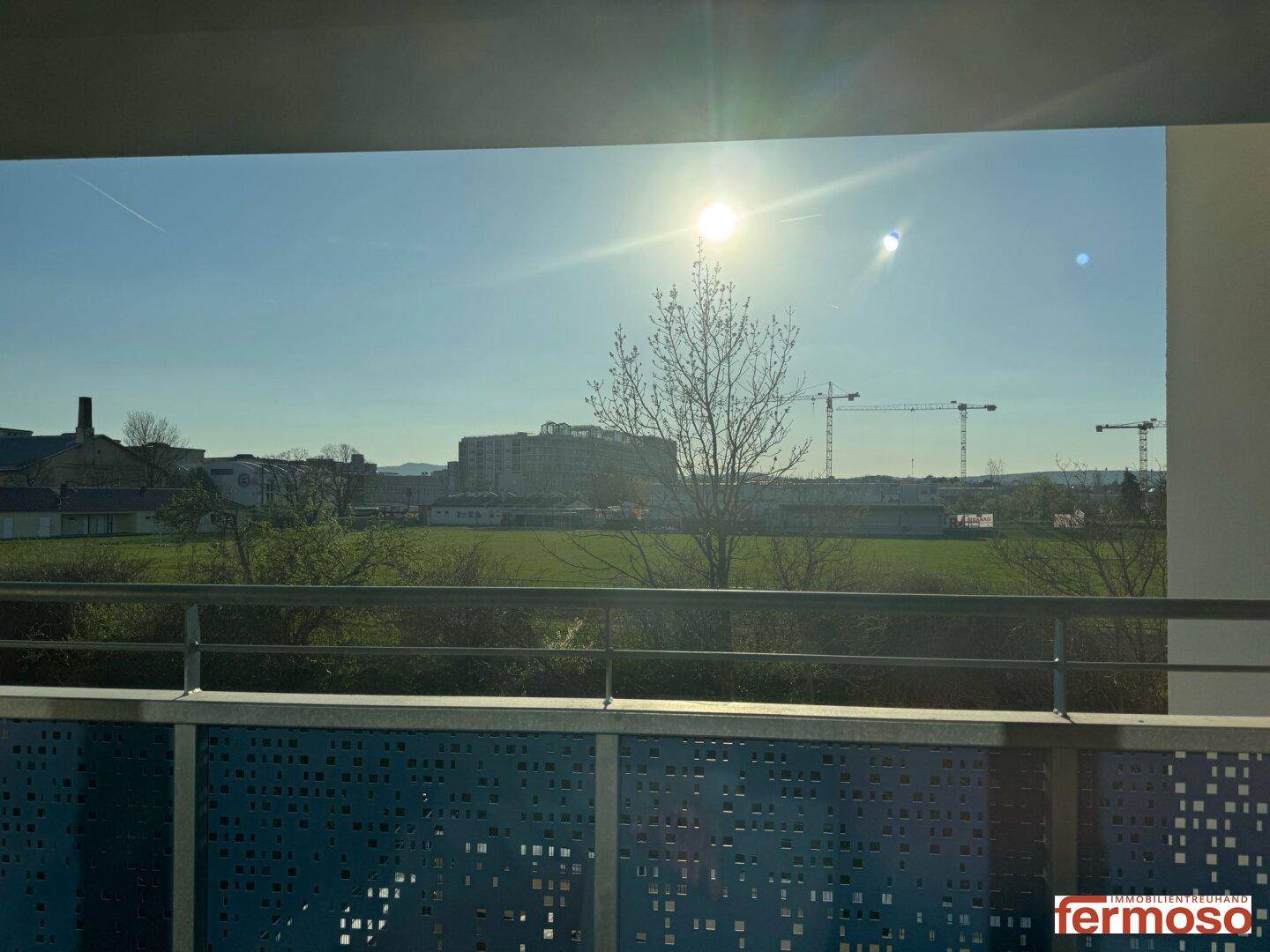Sonniger Balkon mit Blick ins Grüne und auf die Umgebung.