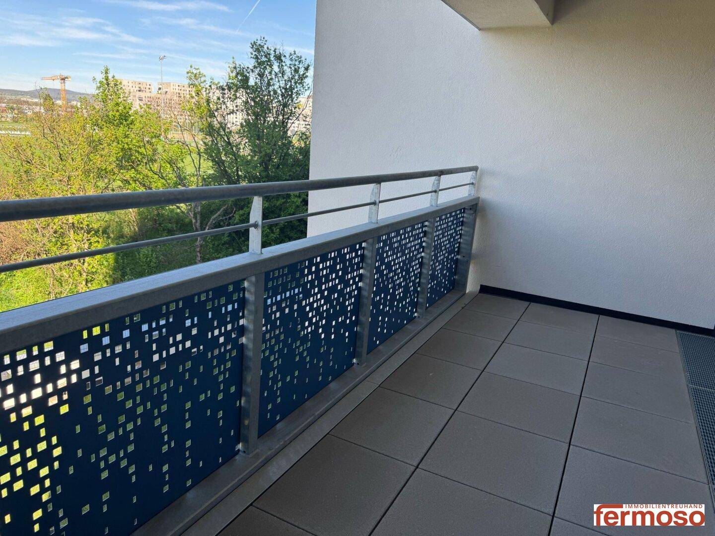 Geräumiger Balkon mit Fliesenboden und moderner Brüstung, bietet einen weiten Blick.