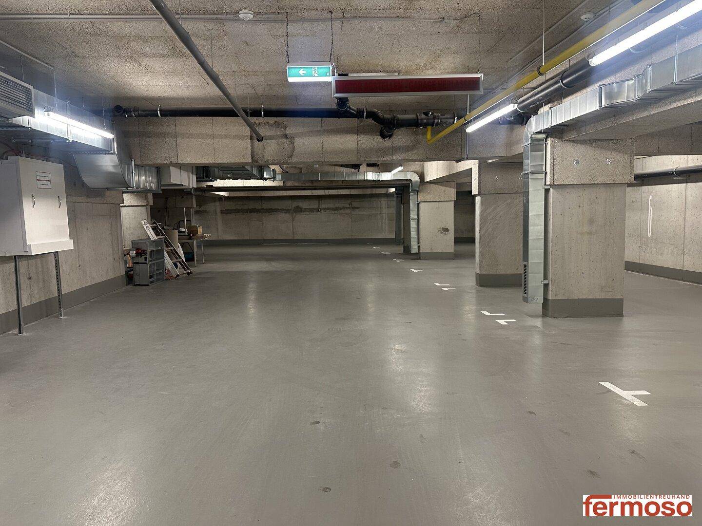 Geräumige Tiefgarage mit markierten Stellplätzen und Beleuchtung.
