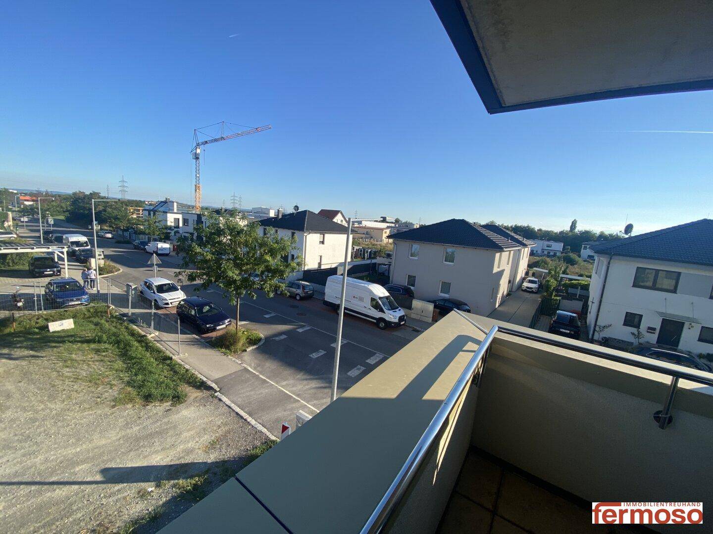 Panoramablick von oben auf die Straße, umliegende Häuser und einen Baukran.