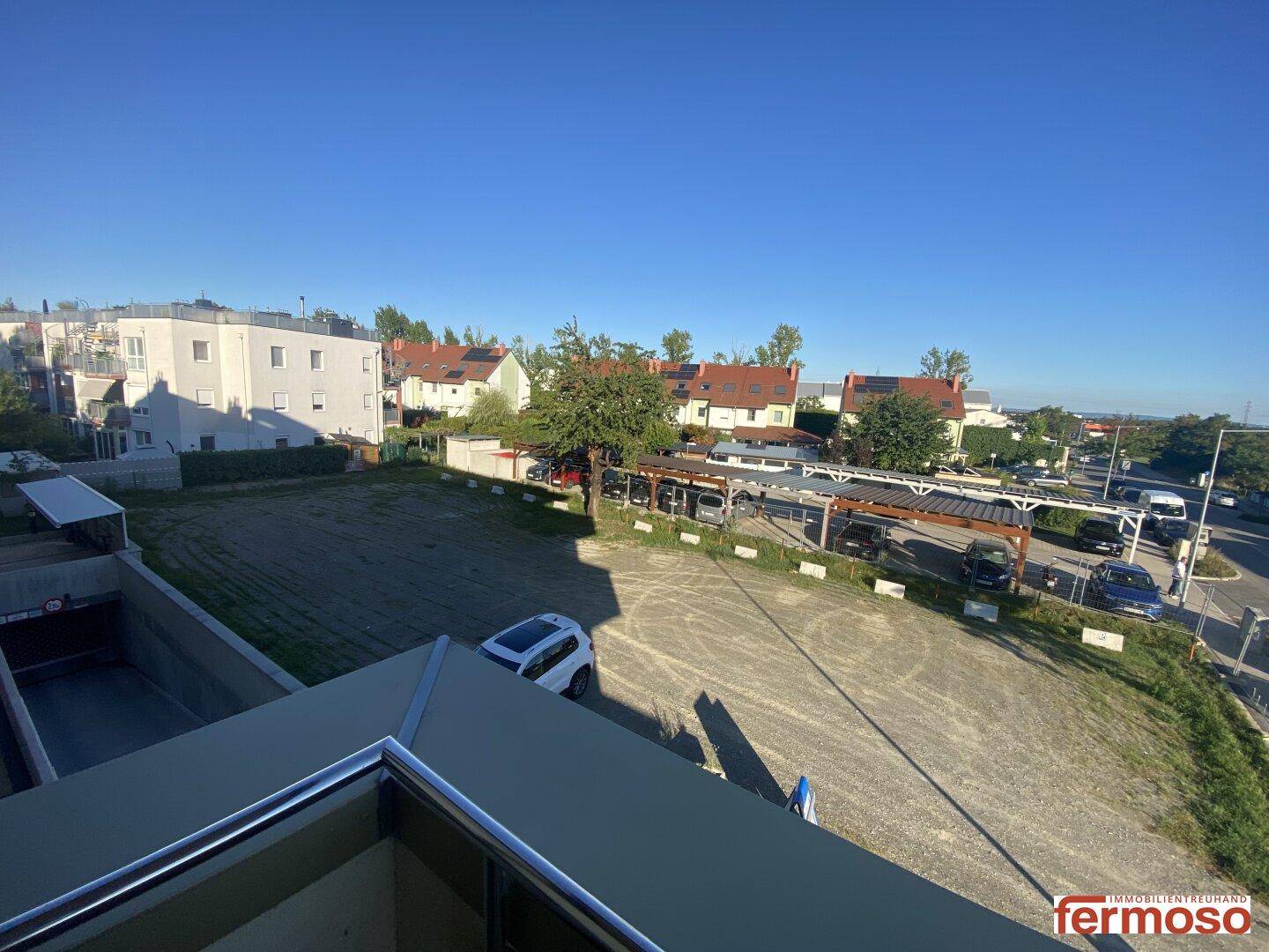 Weitläufiger Blick über die Umgebung mit Parkplätzen und Wohngebäuden.