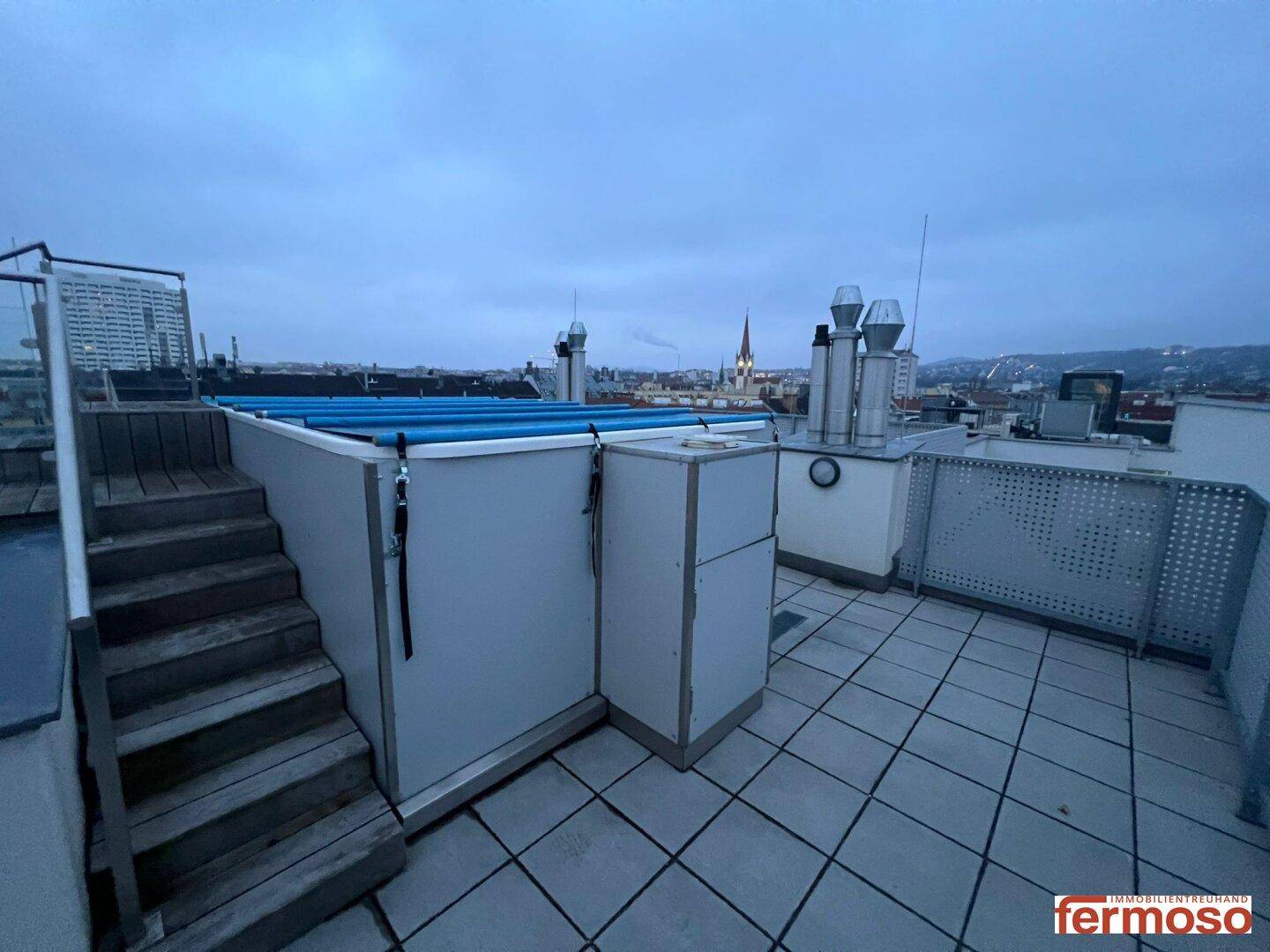 Dachterrasse mit Poolabdeckung und beeindruckendem Blick auf die umliegende Stadt.