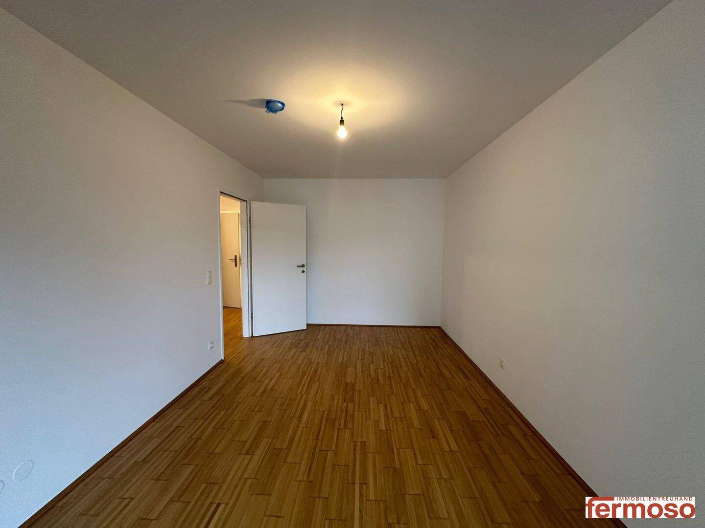 Helles Schlafzimmer mit Parkettboden, ideal für Ruhe und Entspannung.