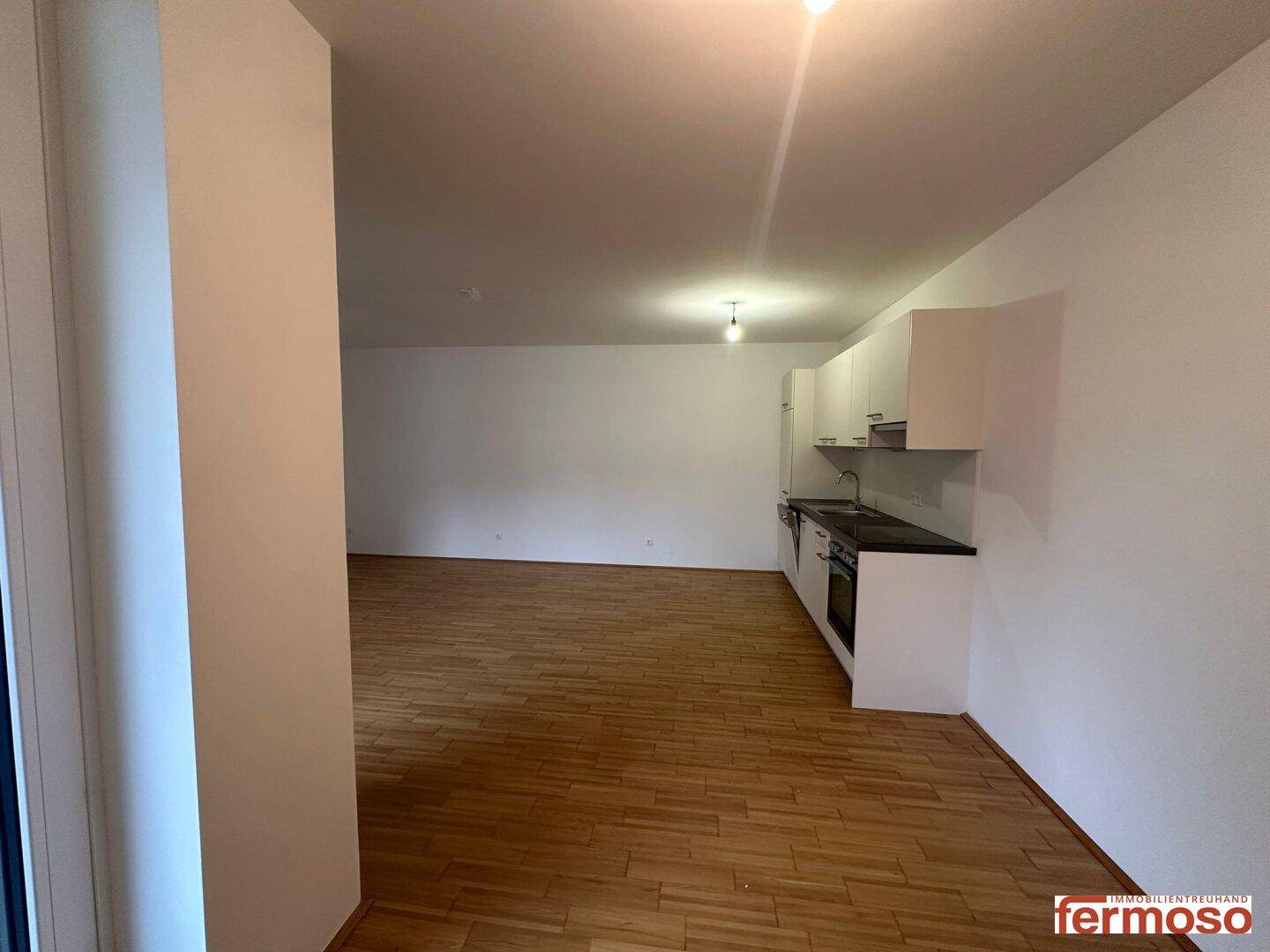 Offener Wohnbereich mit integrierter Küche, Parkettboden und viel Platz für individuelle Gestaltung.