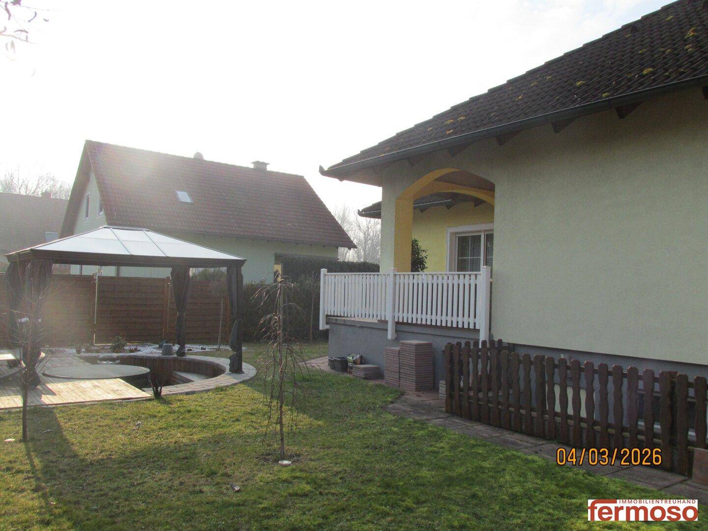 Seitenansicht des Hauses mit Terrasse und Blick auf den gepflegten Gartenbereich.
