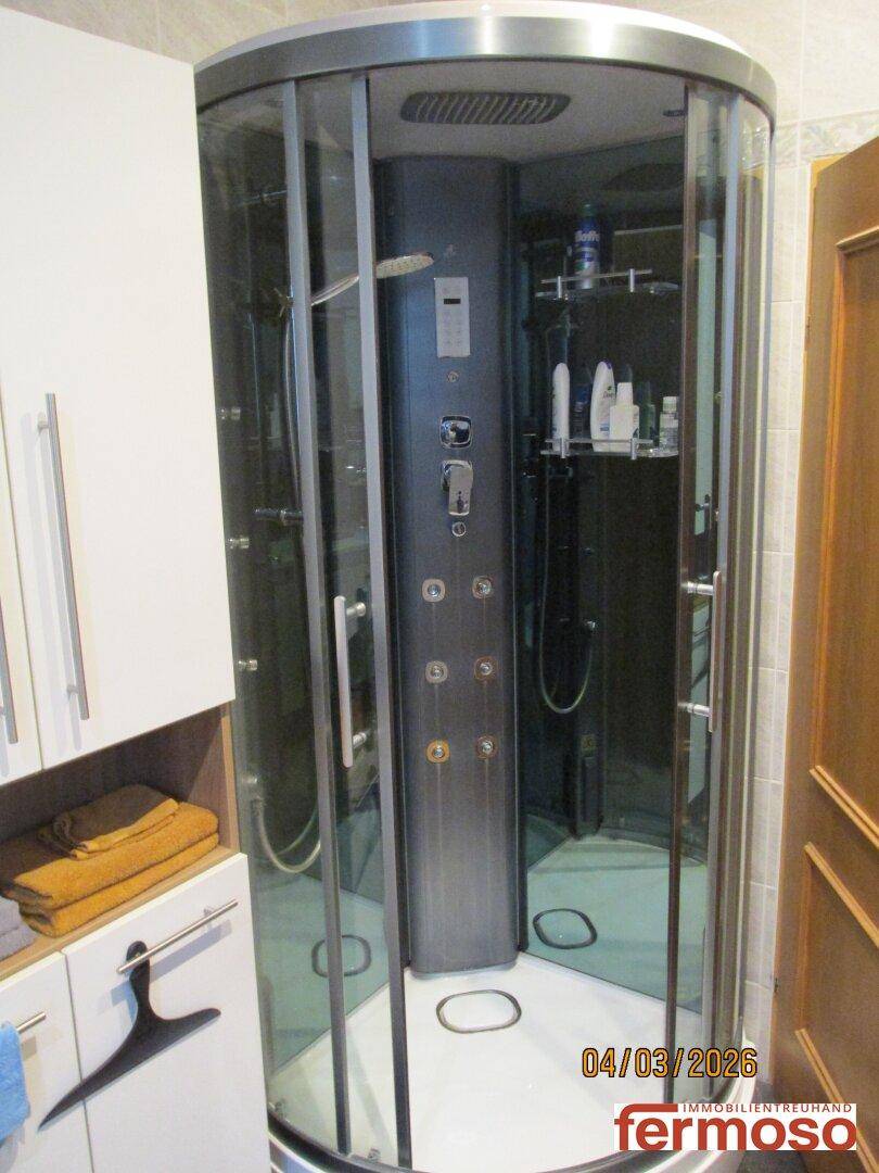 Moderne Duschkabine mit Glaswänden und integrierten Duschpaneelen im Badezimmer.