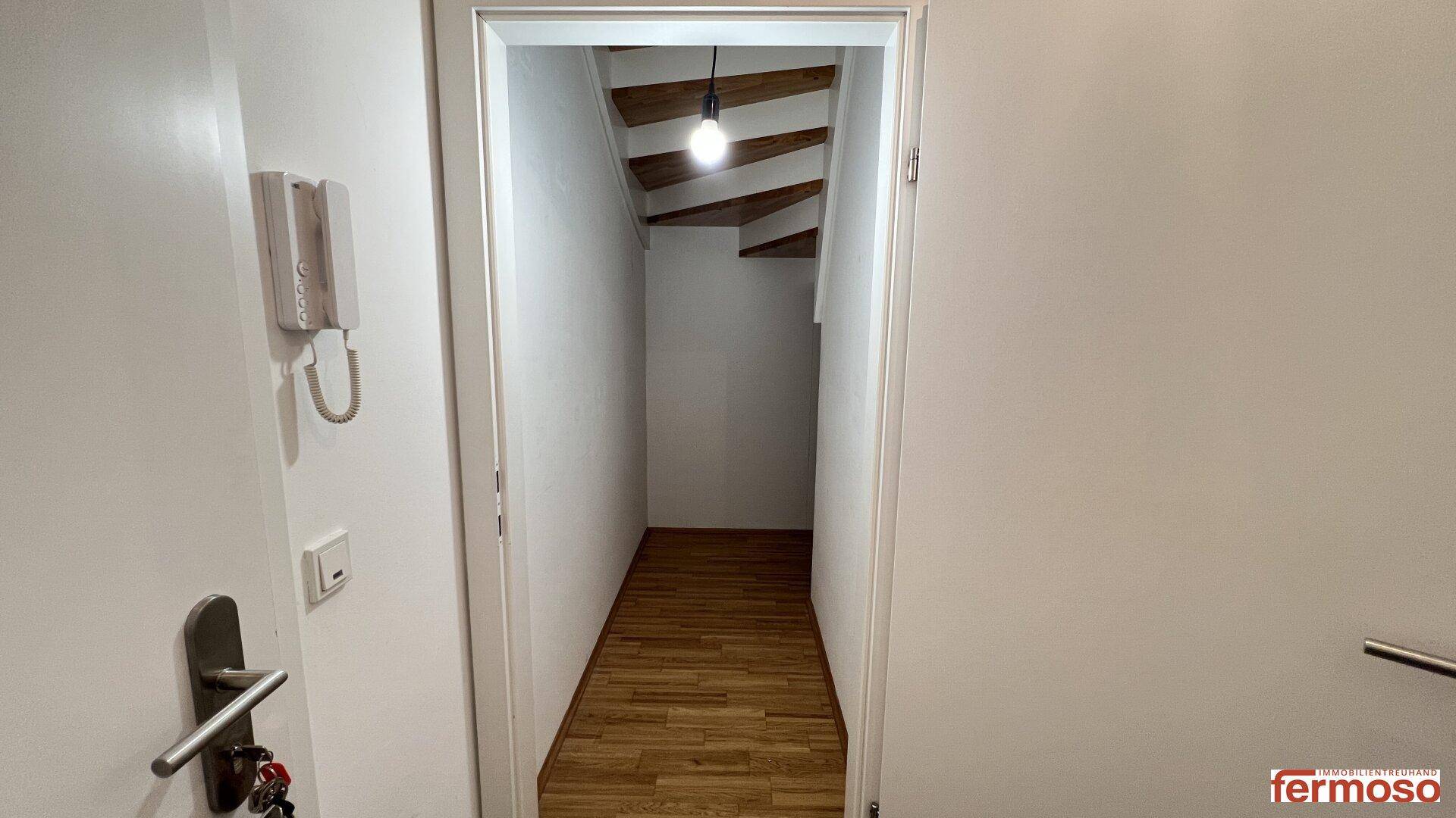 Heller Eingangsbereich mit Holzboden und Treppenaufgang, führt zu den oberen Etagen.