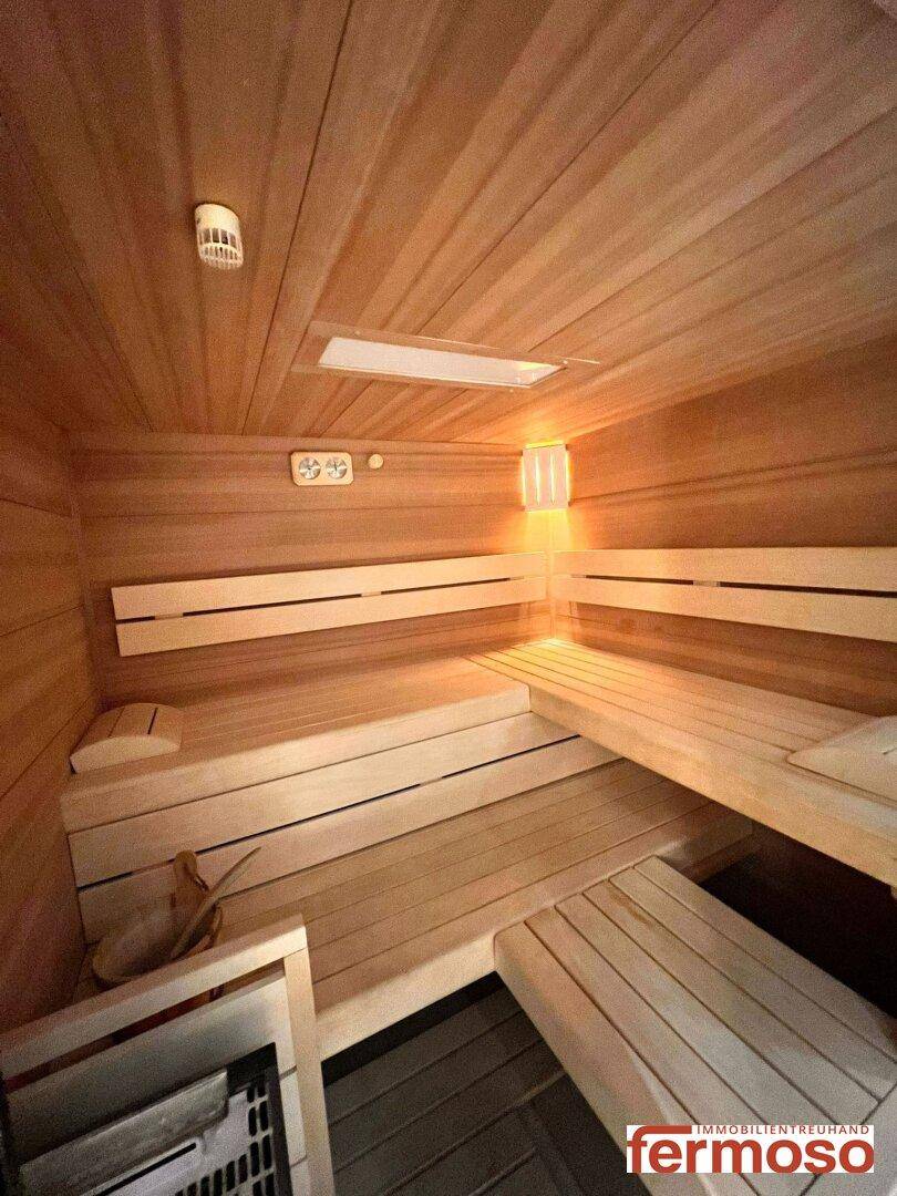 Gemütliche Holzsauna mit Bänken und Heizofen für entspannende Momente.