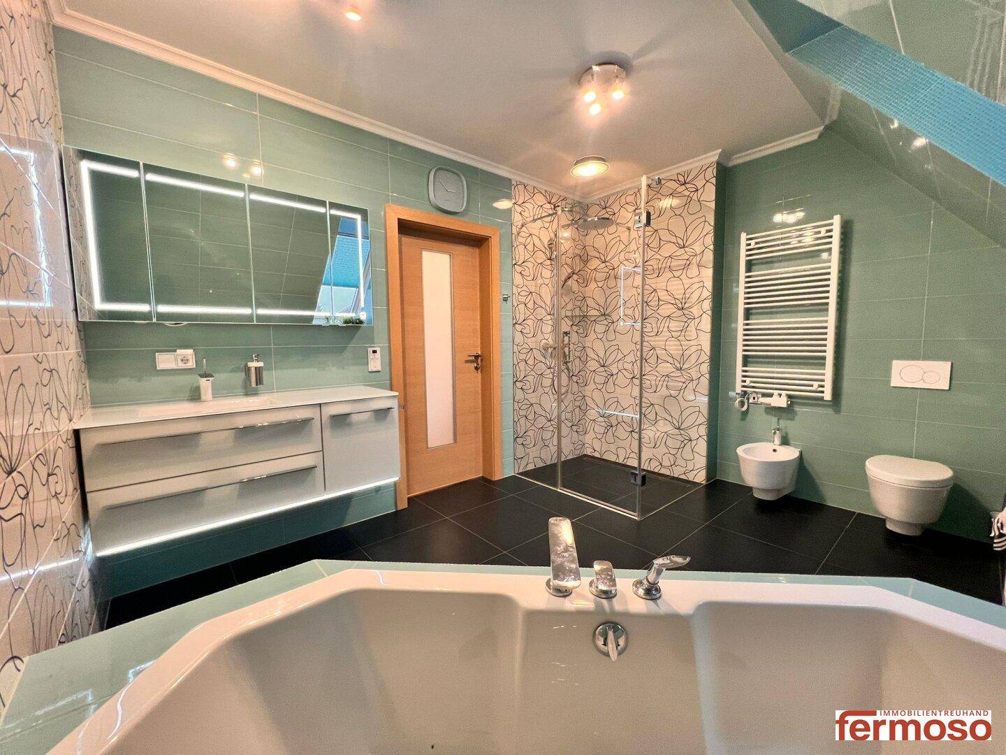 Geräumiges Badezimmer mit Eckbadewanne, begehbarer Dusche, Doppelwaschbecken und Bidet.