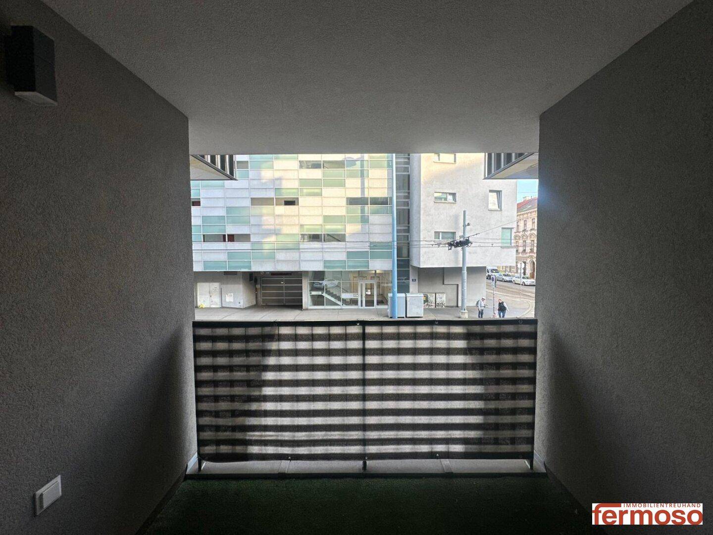Blick von der Loggia auf die umliegenden Gebäude und die Straße.