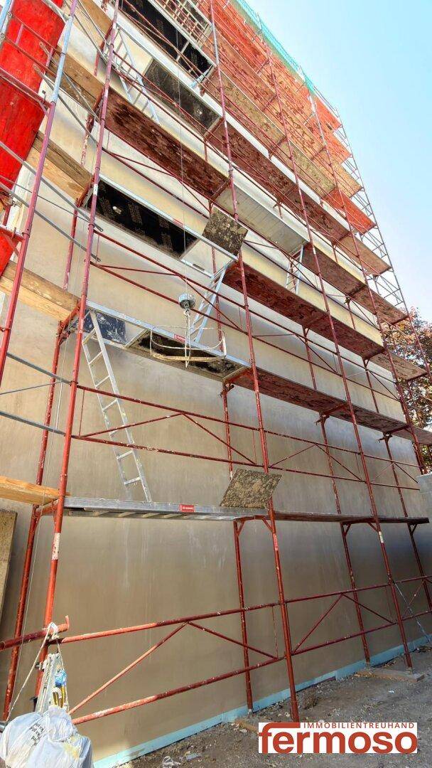 Fassade eines Neubaus mit Gerüst während der Bauarbeiten.
