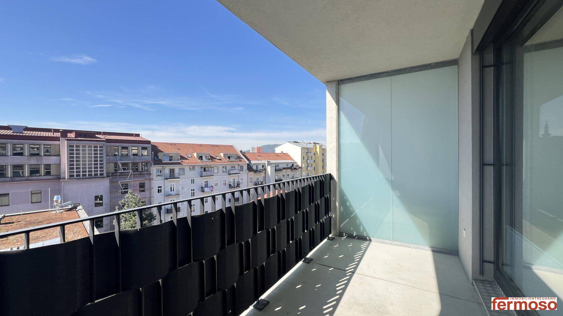 Heller Balkon mit moderner Verglasung und Weitblick über die Stadt.