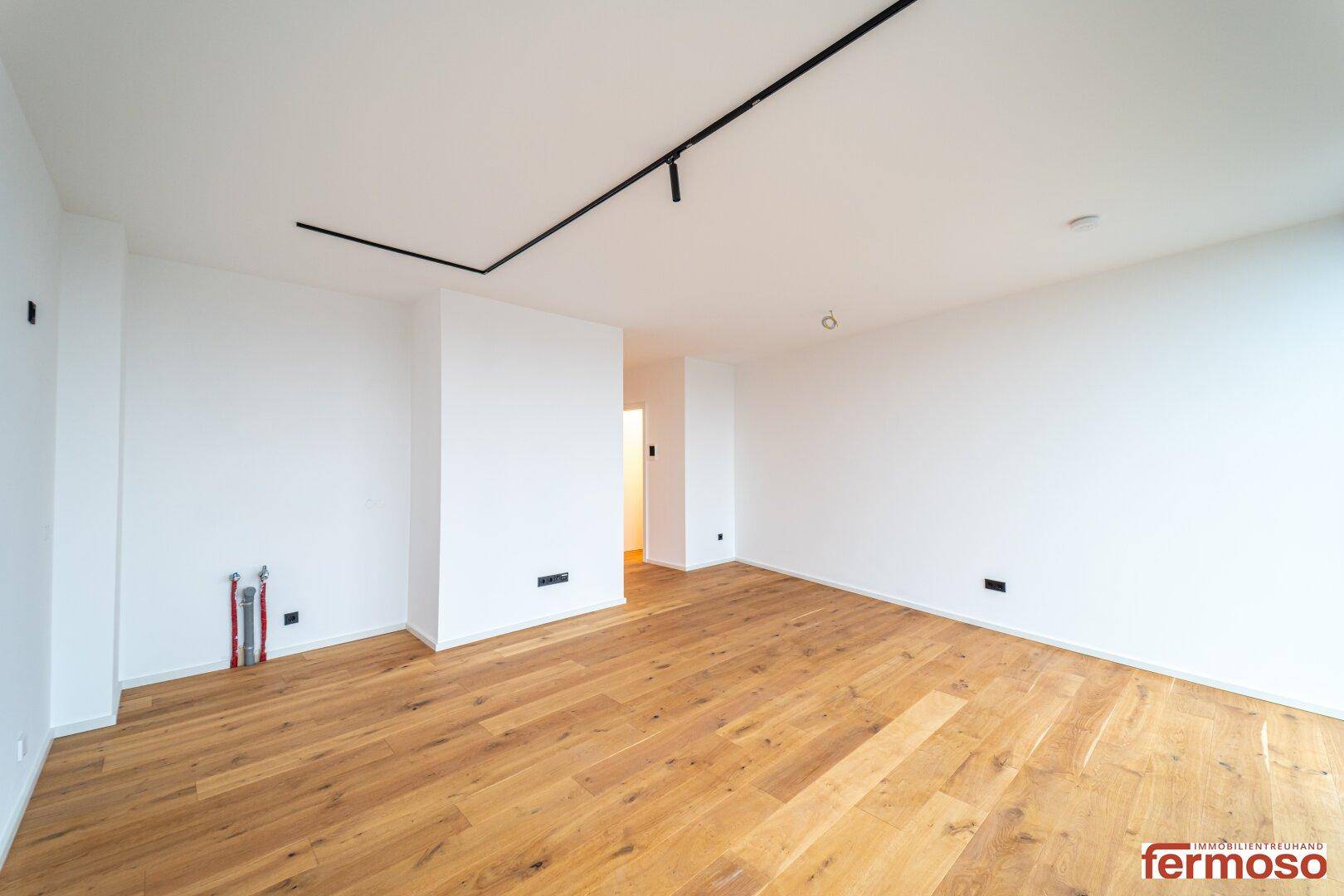 Heller und offener Wohnbereich mit Holzboden, ideal für moderne Wohnkonzepte.