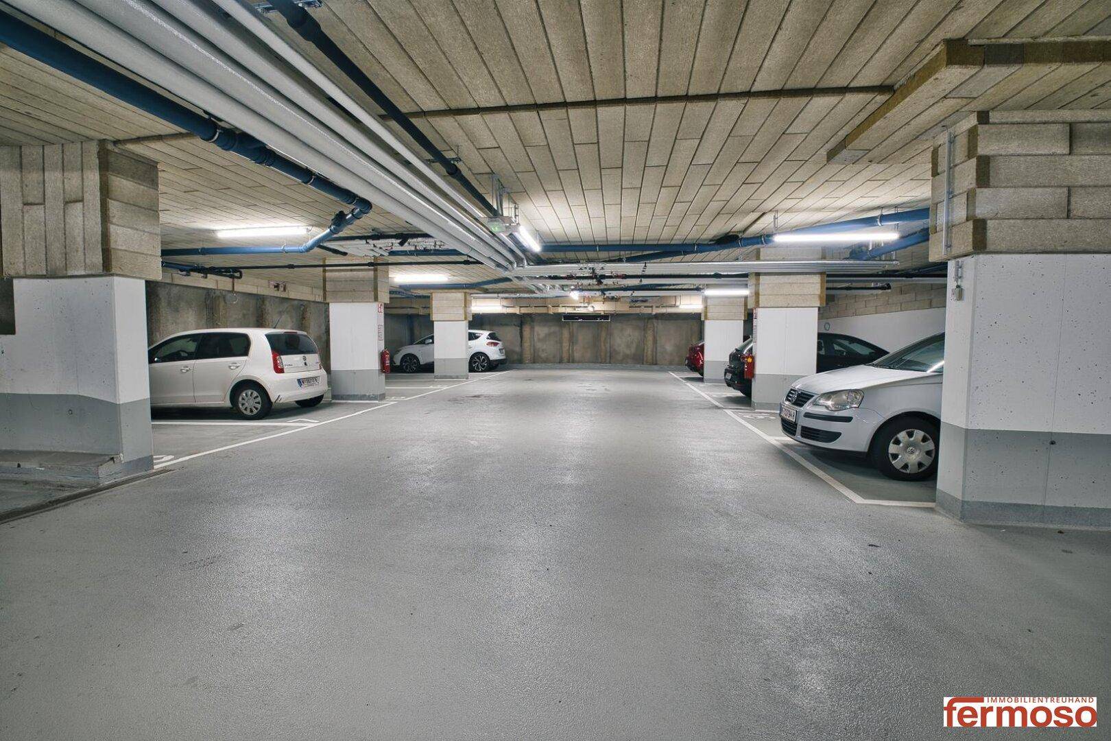 Helle und geräumige Tiefgarage mit mehreren Stellplätzen für Fahrzeuge der Bewohner.