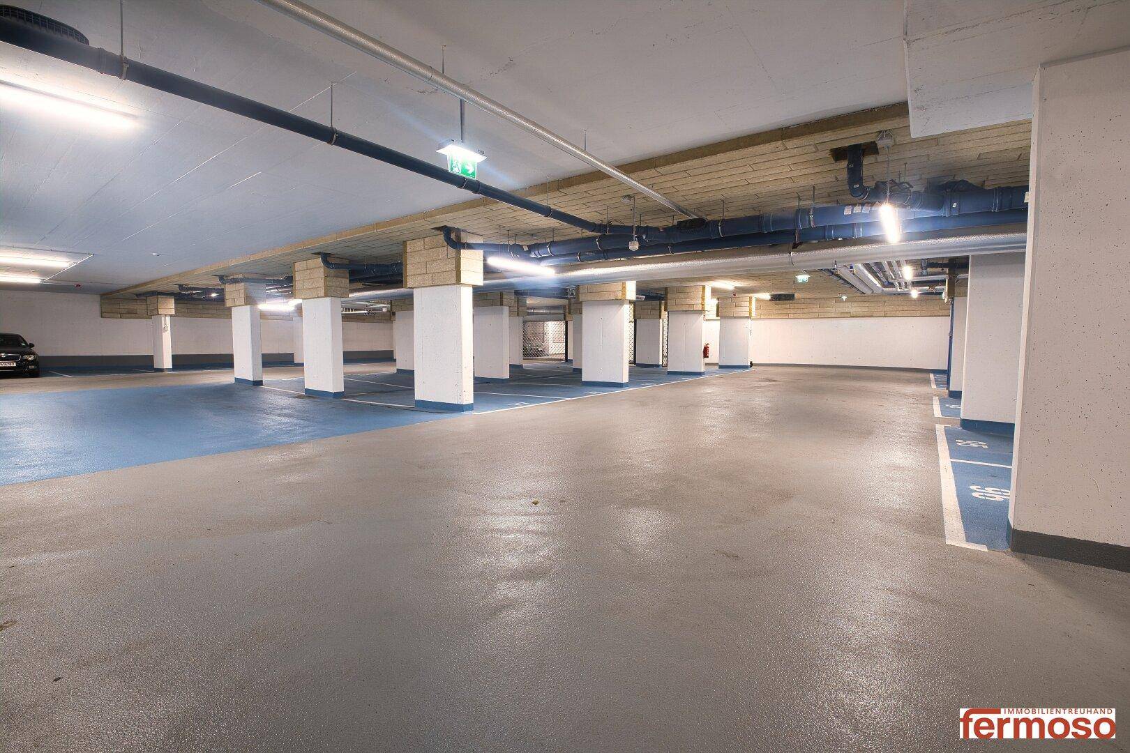 Geräumige Tiefgarage mit markierten Stellplätzen und guter Beleuchtung.