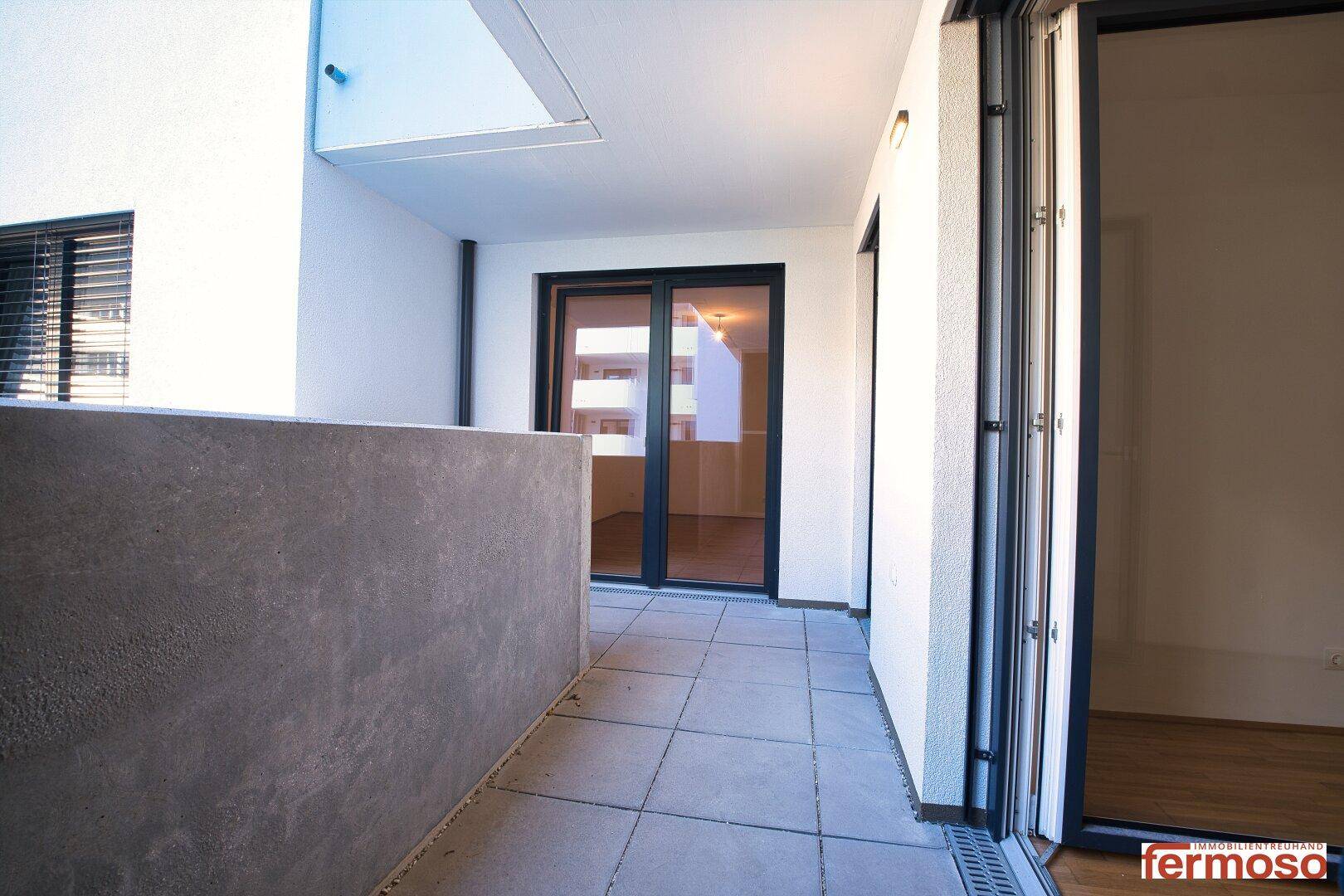 Geräumiger Balkon mit Fliesenboden und Zugang zu den Innenräumen der Wohnung.