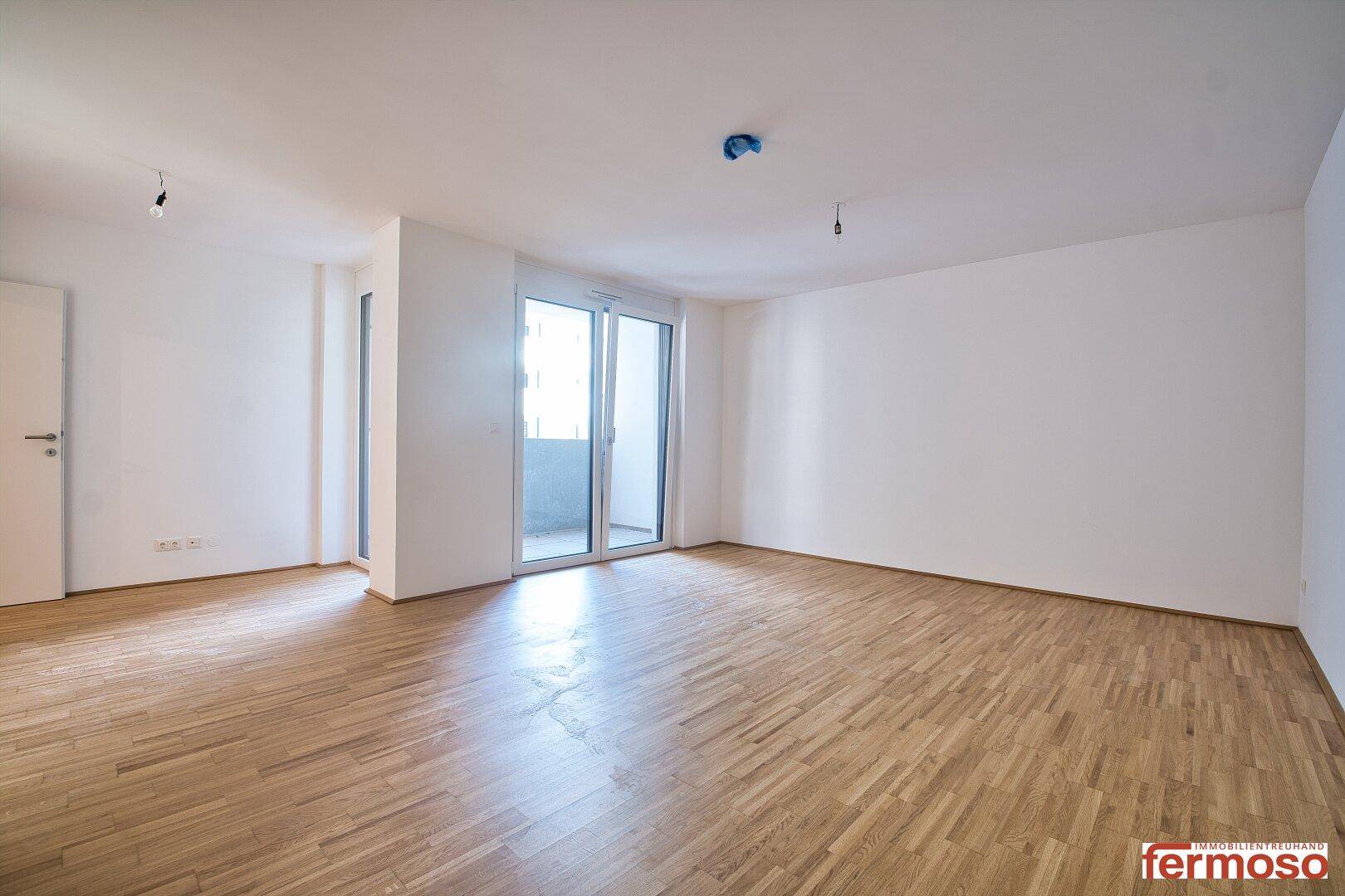 Geräumiges, helles Zimmer mit Parkettboden und Balkonzugang, bereit zur individuellen Gestaltung.