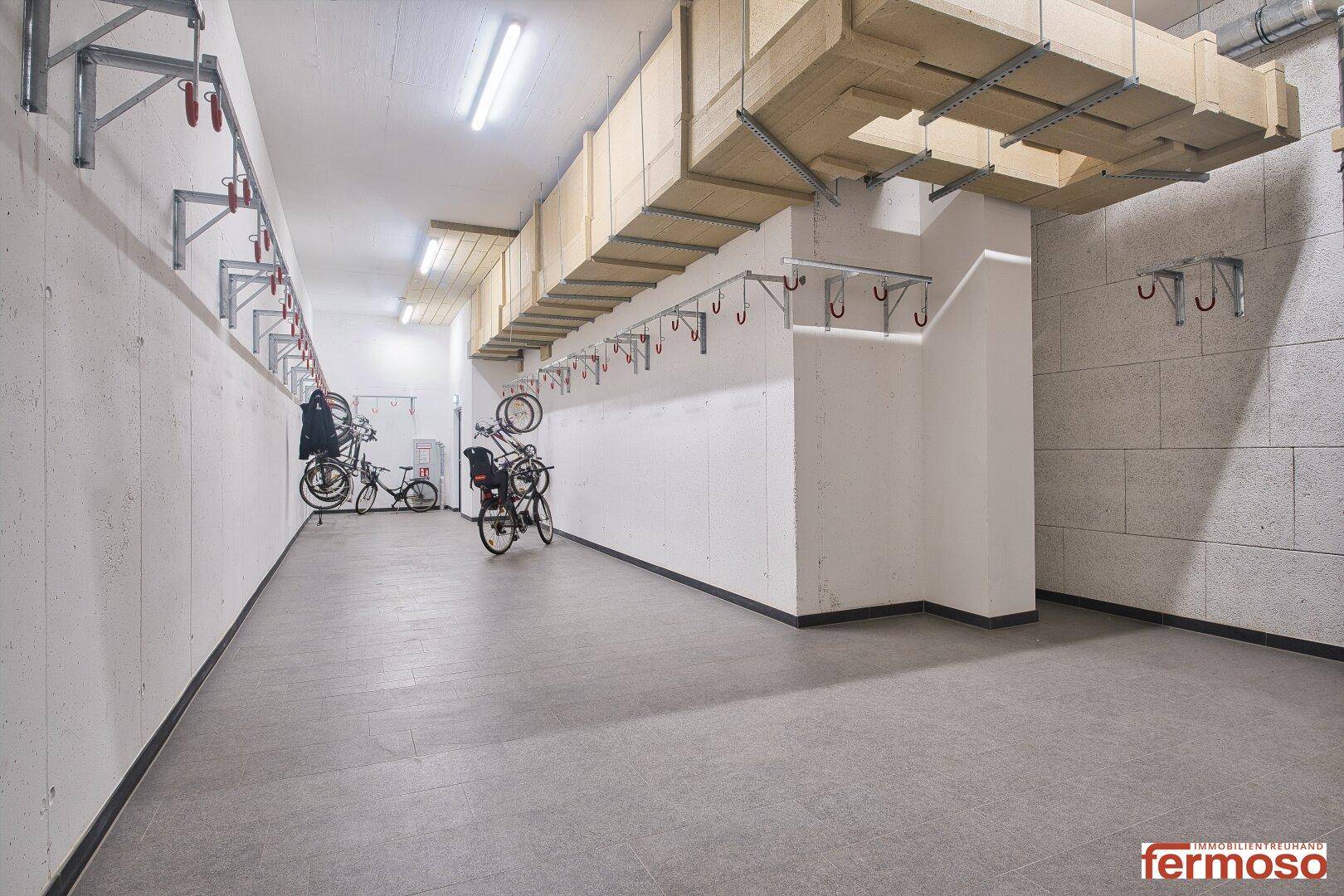 Heller Fahrradraum mit Wandhalterungen und ausreichend Platz für mehrere Fahrräder.