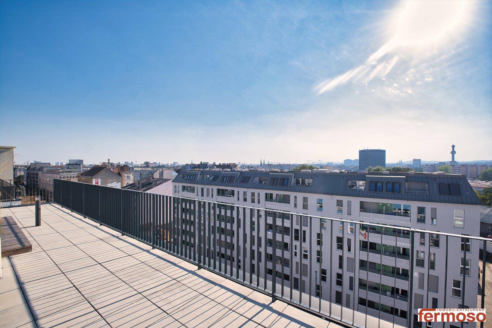 Große Dachterrasse mit Panoramablick über die Stadt und umliegende Gebäude.