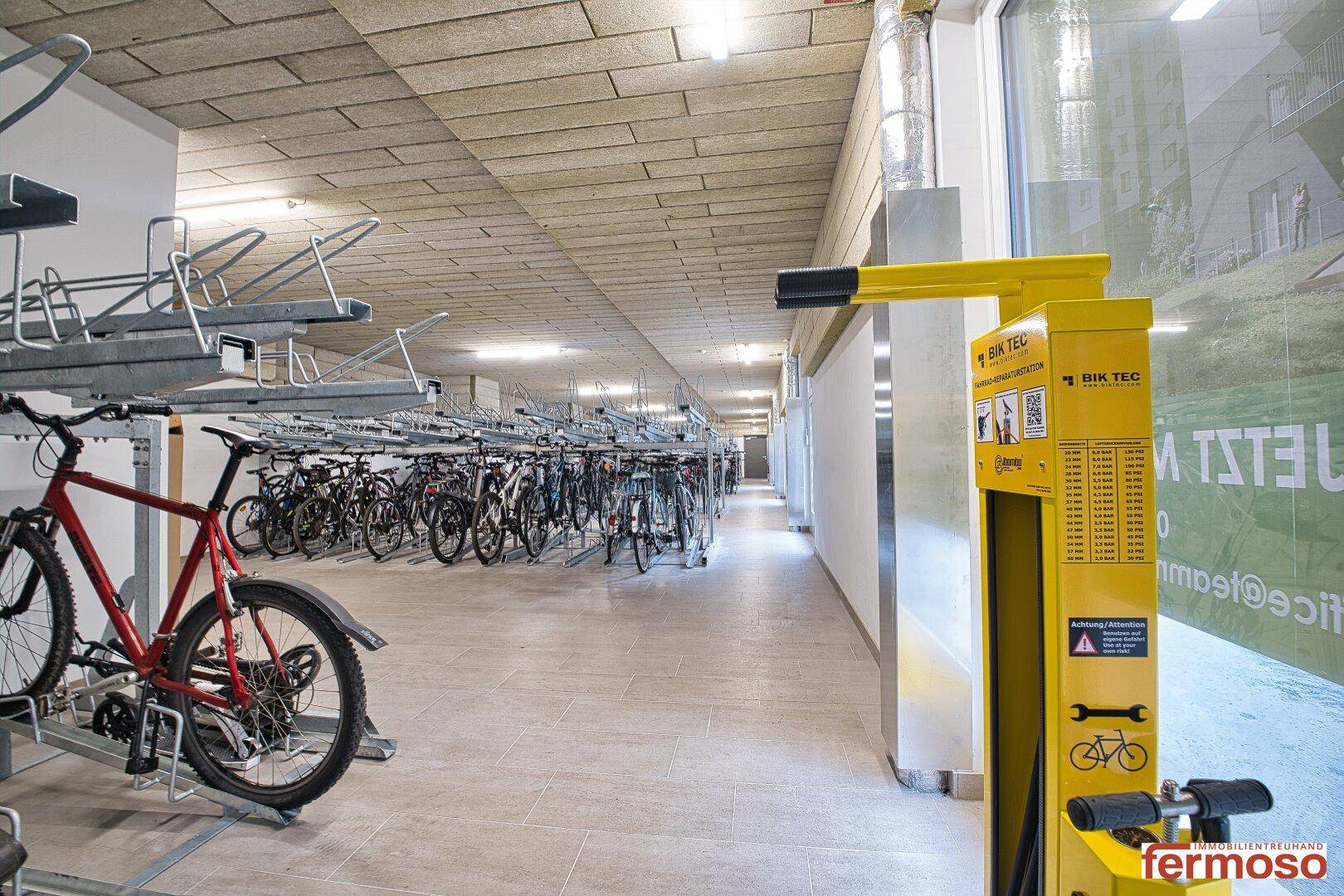 Fahrradraum mit zahlreichen Stellplätzen und einer Reparaturstation.