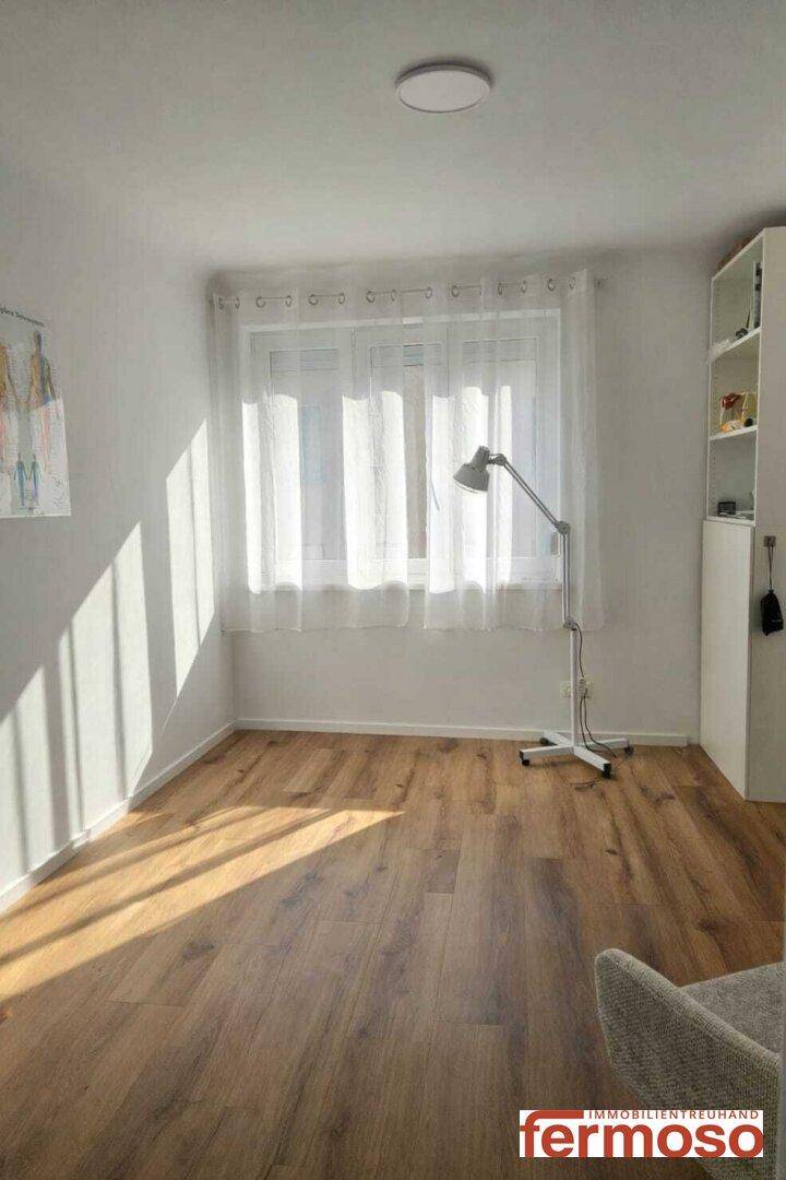 Lichtdurchfluteter Raum mit Holzboden und großen Fenstern, ideal als Schlaf- oder Gästezimmer.