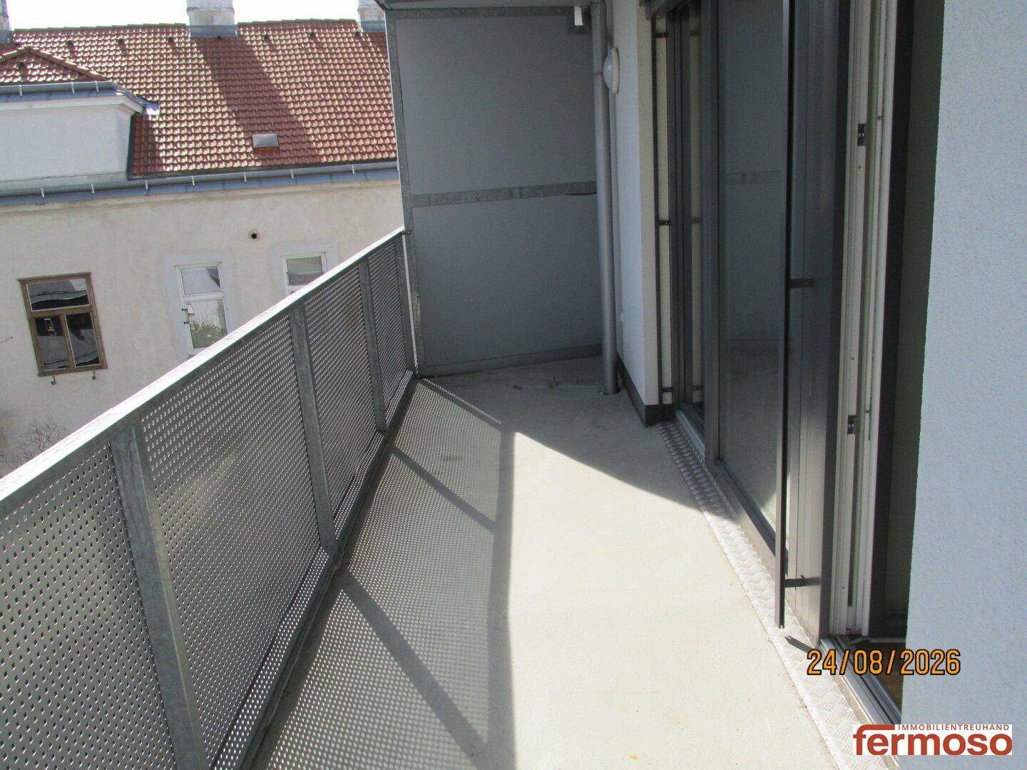 Heller Balkon mit Metallgeländer und Blick auf die umliegenden Gebäude, ideal zum Entspannen.