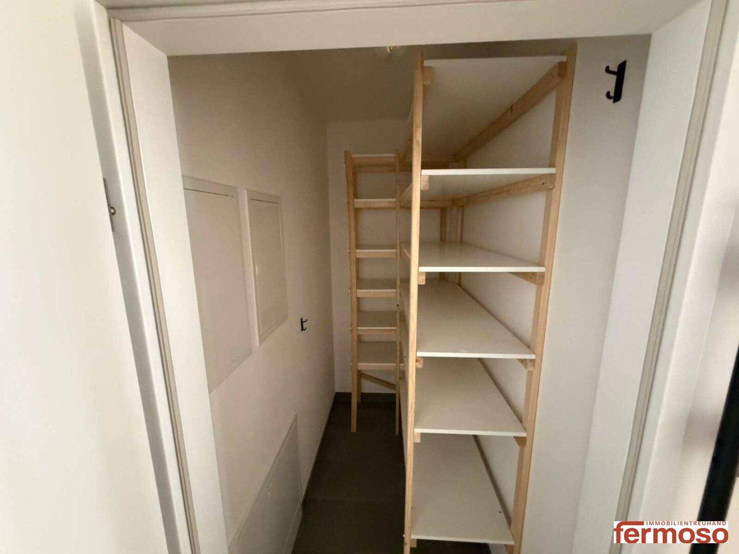 Praktischer Abstellraum mit Holzregalen für zusätzlichen Stauraum.