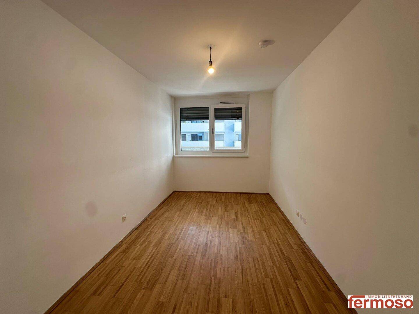 Helles Zimmer mit Parkettboden und Fenster, geeignet als Schlaf- oder Kinderzimmer.