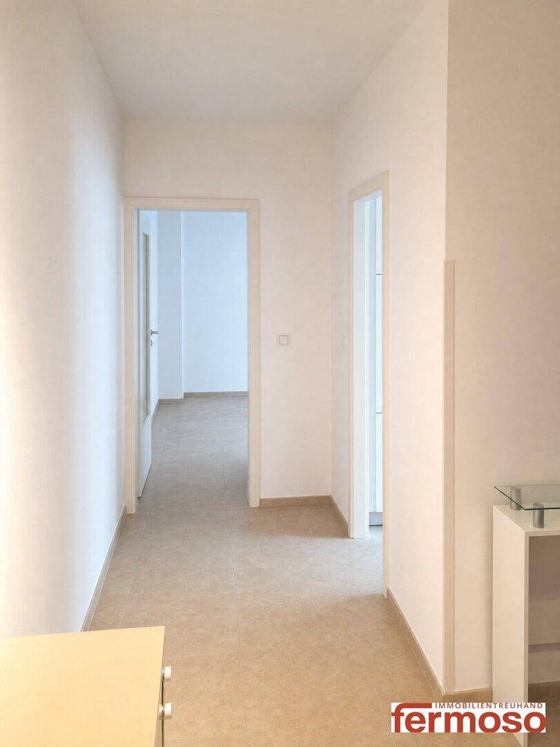 Heller Flur mit Fliesenboden und Zugang zu mehreren Zimmern, modern und funktional.