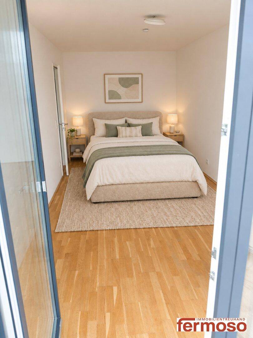 Gemütliches Schlafzimmer mit Doppelbett und Nachttischen, durch die Tür sichtbar.