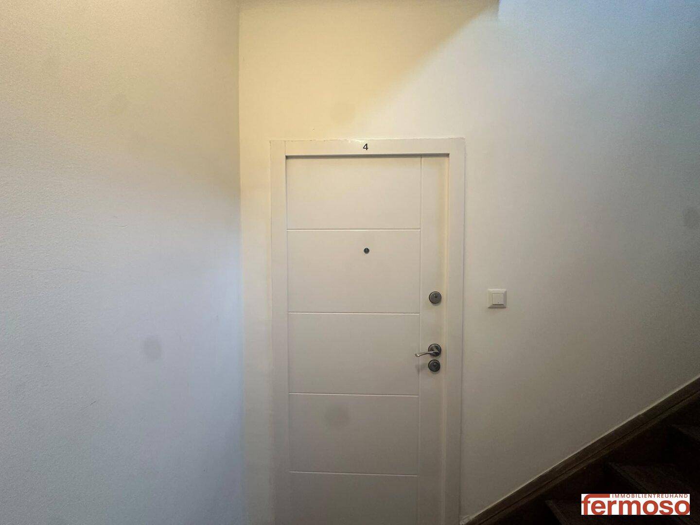 Eingangstür einer Wohnung im Flur, mit moderner Optik und schlichtem Design.