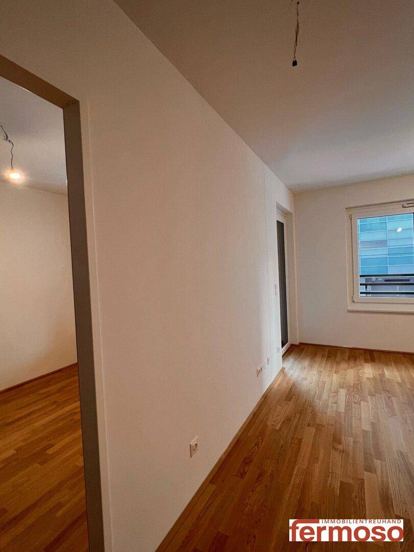 Heller Flur mit Parkettboden und Zugang zu weiteren Räumen.