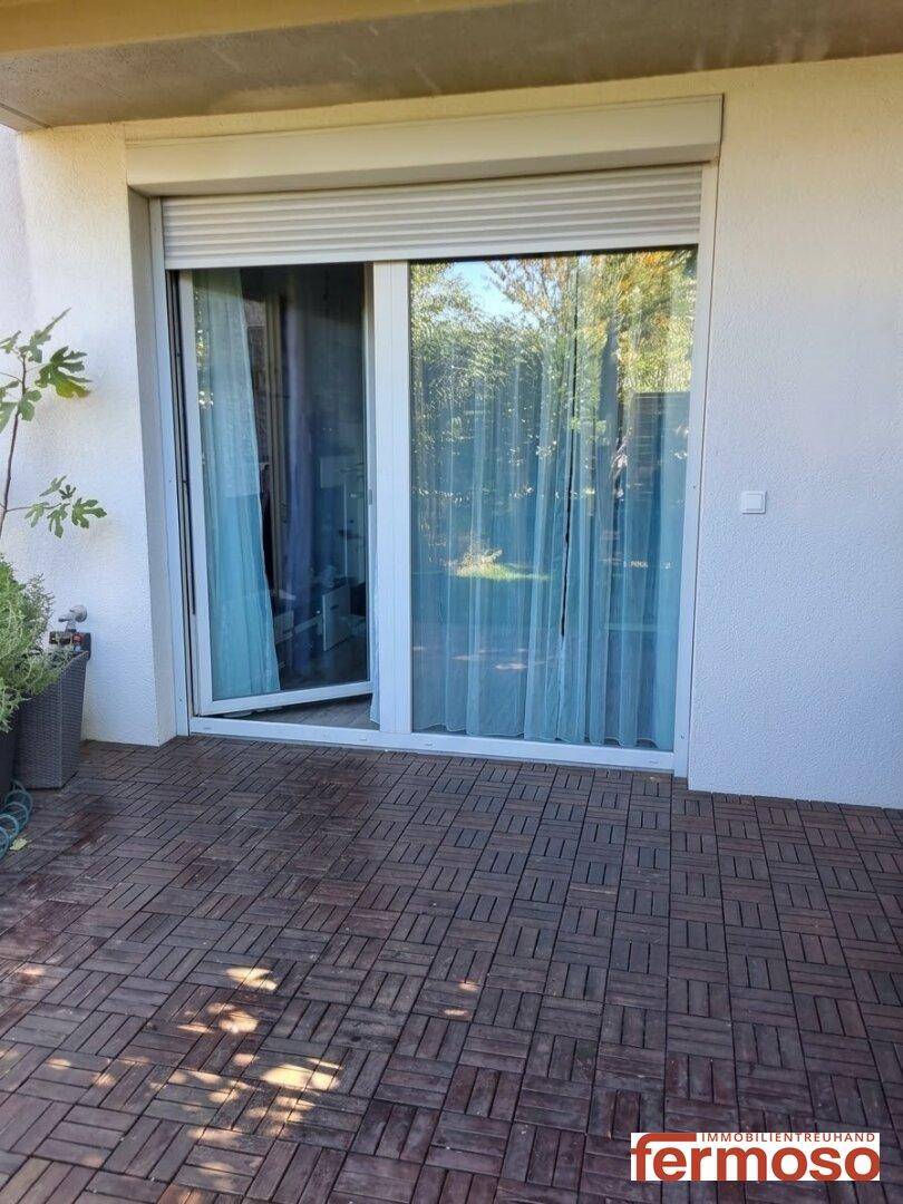 Geräumige Terrasse mit Holzdielen und großer Schiebetür zum Innenbereich.