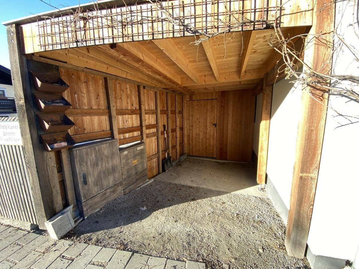 Innenansicht des hölzernen Carports mit sichtbaren Balken und einfacher Ausstattung.