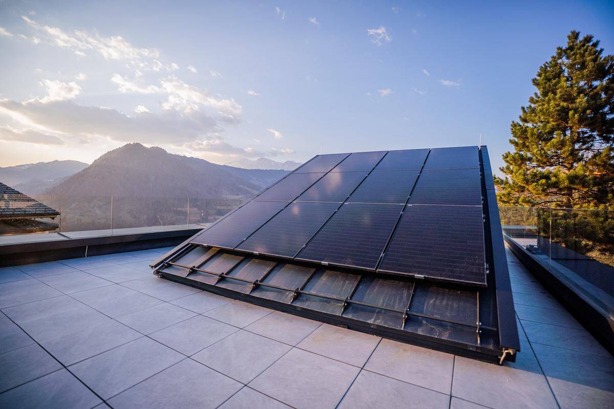 Photovoltaikanlage auf der Dachterrasse, die nachhaltige Energie mit Bergblick verbindet.