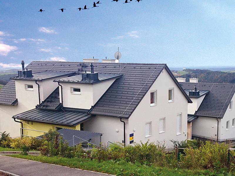 Reihenhäuser mit Satteldächern in ländlicher Umgebung und weitem Blick über die Landschaft.