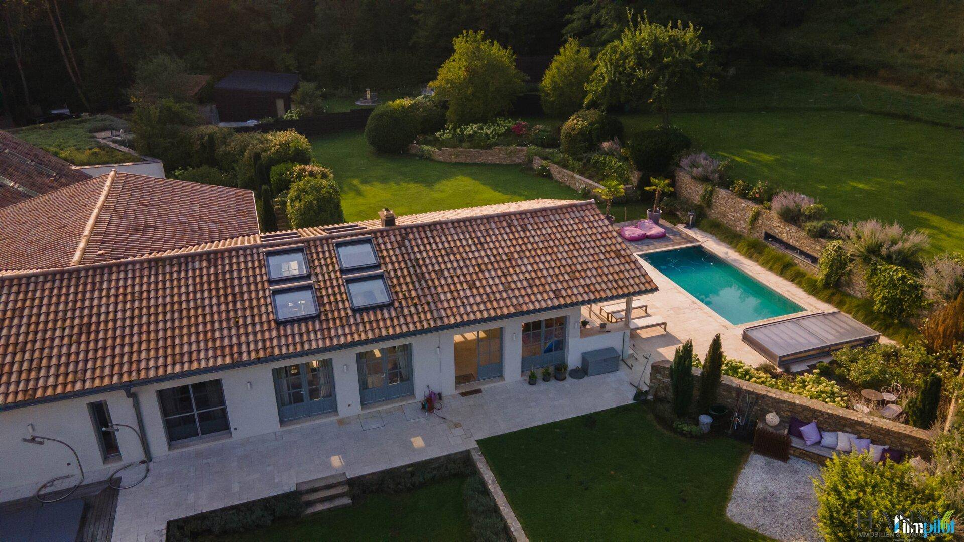 Dachansicht des Hauses mit Poolbereich und einem Teil des gepflegten Gartens in sonniger Lage.