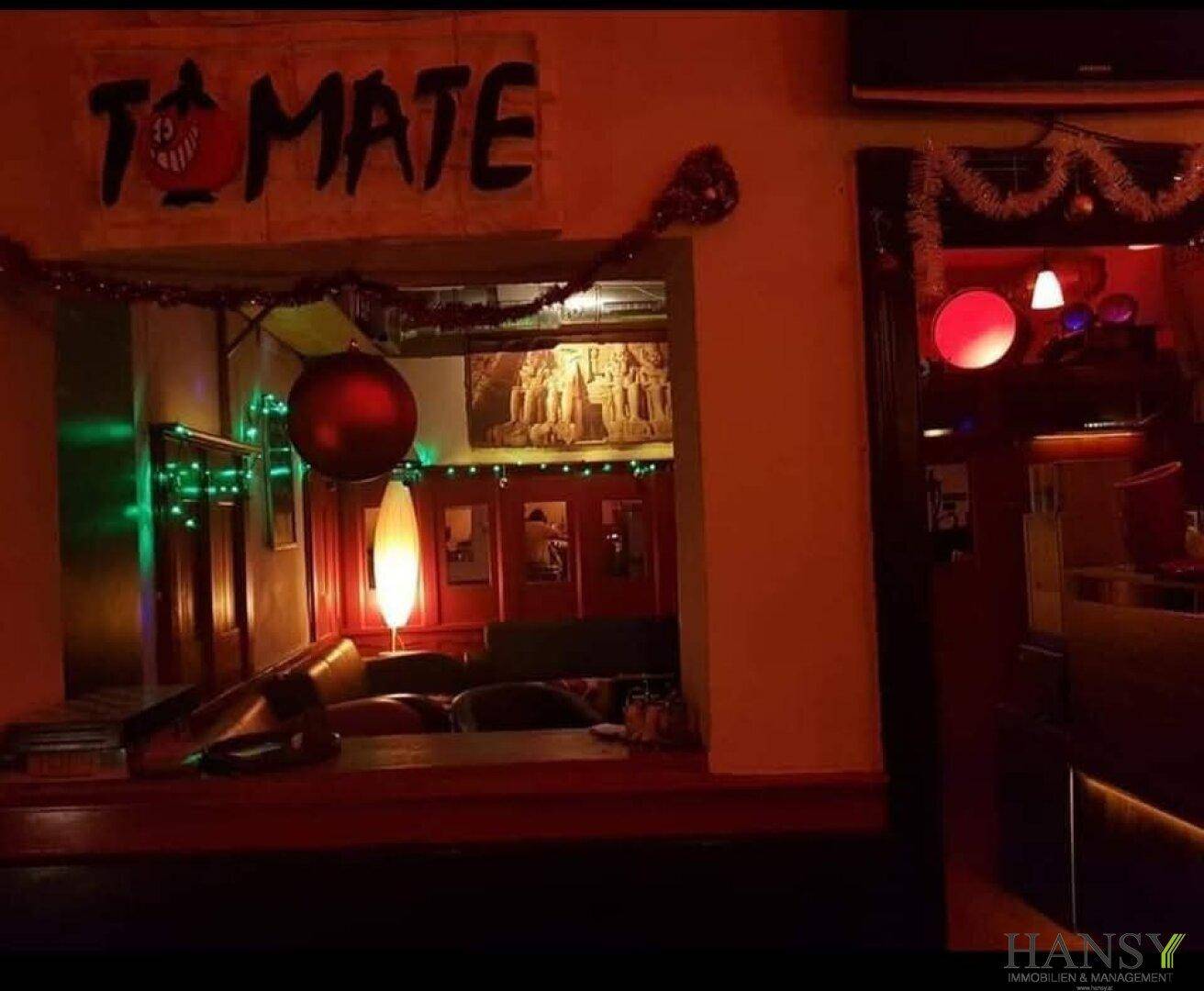 Dunkel beleuchteter Lounge-Bereich mit roten Akzenten und festlicher Weihnachtsdekoration.