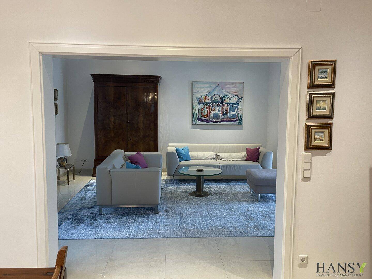 Geräumiges Wohnzimmer mit bequemen Sofas, modernem Teppich und hellem Ambiente.