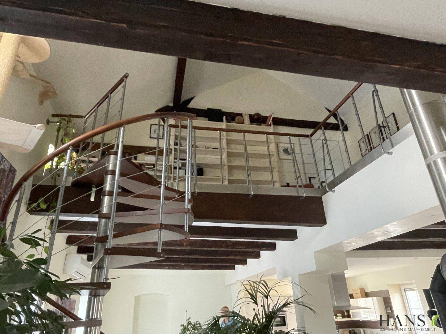 Obere Galerie mit Wendeltreppe und Blick auf den offenen Wohnbereich.